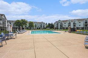 Kalamazoo townhouse for rent - A large outdoor swimming pool surrounded by lounge chairs at Gull Prairie/Gull Run Apartments and Townhomes, Kalamazoo