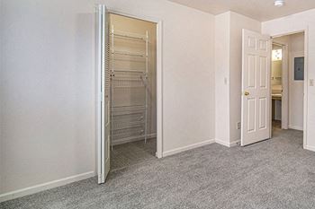 A bedroom with a walk in closet with organizers