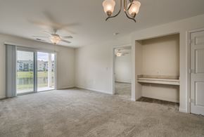 Columbia townhouse for rent - A spacious room with a ceiling fan and a large window with a view of a building outside.