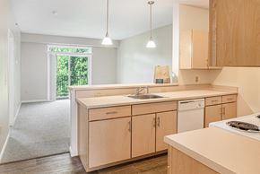 Madison apartment for rent - A kitchen with wooden cabinets and a white appliances at Limestone Creek Apartment Homes, Madison, AL