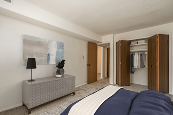 A bedroom with a large bed and a dresser with a lamp on it