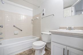 Kalamazoo apartment for rent - A white toilet sits next to a bathtub in a bathroom at Madeira Apartments, Michigan