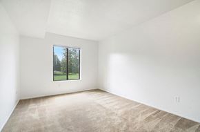 Kalamazoo apartment for rent - A large empty bedroom with a carpeted floor and a window at Madeira Apartments, Kalamazoo, MI