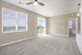 Grand Rapids apartment for rent - A spacious living room with a 9 foot ceiling, ceiling fan and carpeted floor at Meadowbrooke Apartment Homes in Kentwood, MI 49512