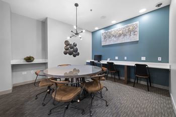 A conference room with a blue accent wall and a round table with chairs