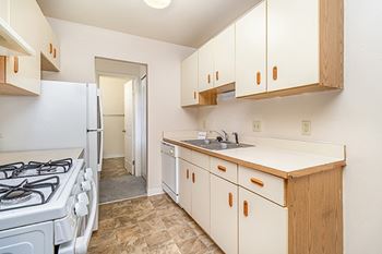 A kitchen with a white appliances and wooden cabinets