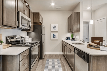 A kitchen with stainless steel appliances and white countertops