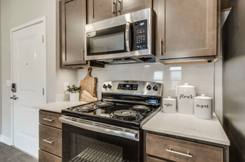 A kitchen with stainless steel appliances and white countertops