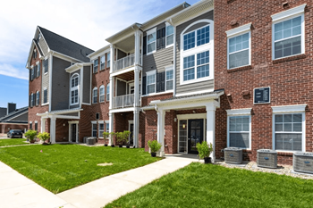 A large brick building with a grassy area in front of it