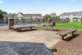 Michigan City apartment for rent - A park area with benches and a mailbox in front of apartment buildings.