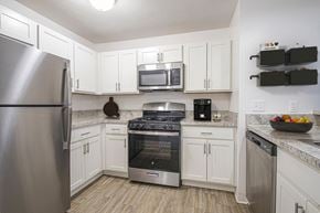 Elkhart apartment for rent - A kitchen with white cabinets and a stainless steel appliances at North Pointe Apartments, Elkhart