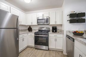 Oak Creek apartment for rent - A kitchen with white cabinets and stainless steel appliances at Oak Shores Apartments in Oak Creek, WI