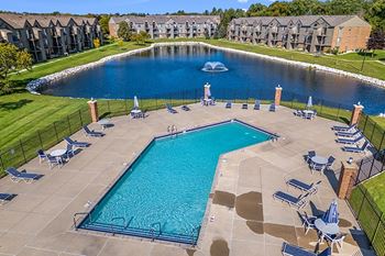 A large swimming pool surrounded by lounge chairs and umbrella