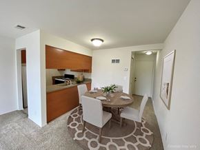 Westland apartment for rent - a dining area with a table and chairs and a kitchen in the background at The Landings Apartments, Westland, MI