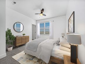 Grimes apartment for rent - A bedroom with a bed, a ceiling fan, walk-in closet and a window with blinds at The Reserve at Destination Pointe apartments, Grimes, IA
