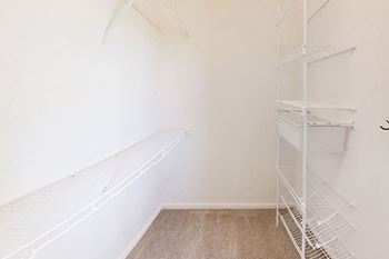 A walk-in closet with wardrobe organizers