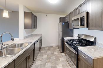 A kitchen with a breakfast bar and stainless-steel appliances