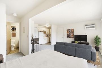 Kalamazoo apartment for rent - A living room with a grey couch and a television on the wall.