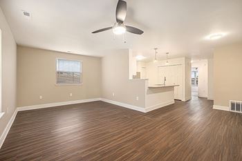 An enlarged living room with a ceiling fan and hard-surface flooring