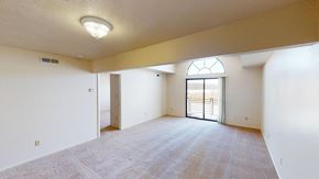 Fort Wayne apartment for rent - spacious living room with a cathedral ceiling and a door to a balcony at South Bridge Apartments in Fort Wayne, Indiana