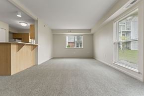 Wichita apartment for rent - An enlarged living room with a carpeted floor and a window with blinds at Stoney Pointe Apartment Homes, Kansas