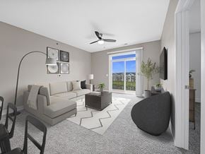 West Des Moines apartment for rent - A modern living room with a grey sofa, a black armchair, and a television on the wall at Strathmore Apartment Homes, West Des Moines, 50266
