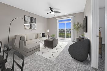 A living room with a 9' ceiling, a grey sofa, an armchair, and a coffee table
