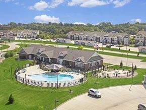 West Des Moines apartment for rent - A large leasing, community building, and fitness center with a pool behind it at Strathmore Apartment Homes, Iowa