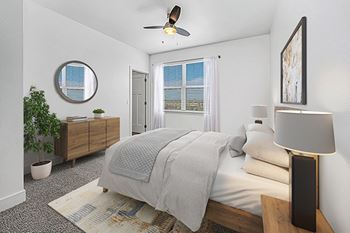 A bedroom with a bed, a ceiling fan, and a closet 