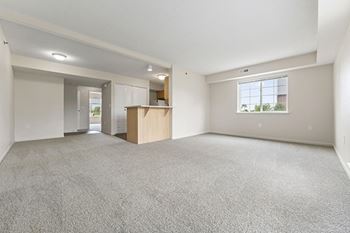 A kitchen with white appliances and an enlarged living room