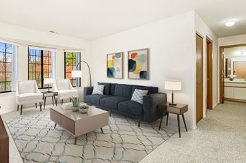 Oak Creek apartment for rent - A living room with a blue couch, a coffee table, and a painting on the wall.