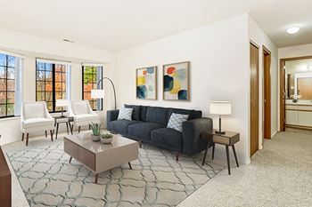 A living room with a bay window, a grey couch, and a coffee table bay window in living room