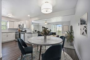 Byron Center apartment for rent - A modern kitchen with a dining table set for four at Byron Lakes Apartments in Byron Center, MI