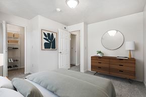 Elkhart apartment for rent - A bedroom with a bed, dresser, mirror and walk in closet at The Highlands Apartments in Elkhart, IN