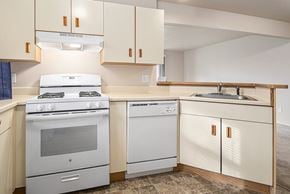 Perrysburg apartment for rent - A kitchen with a white stove and dishwasher at Tracy Creek Apartments, Ohio