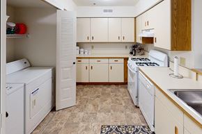 Perrysburg apartment for rent - A kitchen with white appliances and wooden cabinets at Tracy Creek Apartment Homes in Perrysburg, OH