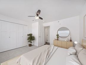 Elkhorn apartment for rent - A bedroom with a bed, dresser, mirror, and a ceiling fan at Trade Winds Apartment Homes, Elkhorn, Nebraska