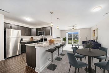 A modern kitchen with a breakfast bar and dining table and chairs