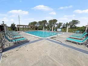 Elkhorn apartment for rent - A large outdoor swimming pool with lounge chairs at Trade Winds Apartment Homes, Elkhorn, NE, 68022