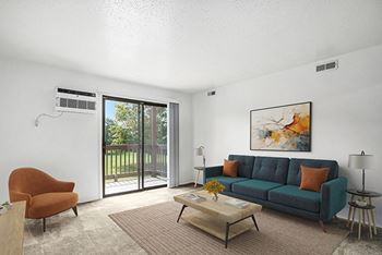 A living room with a couch, a chair, a coffee table, and a slider to a private balcony
