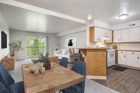 Jackson apartment for rent - A modern kitchen with a dining table and chairs at Trillium Pointe Apartment Homes, Jackson, MI