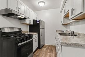 Portage apartment for rent - A kitchen with stainless steel appliances and white shaker cabinets at Walnut Trail Apartments, Michigan