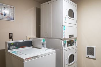 A laundry room with four washing machines and a washer and dryer