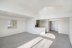Elkhorn apartment for rent - A spacious living room with a cathedral ceiling and a window at West Hampton Park Apartments in Elkhorn, NE 68022