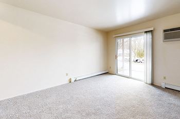 A living room with a carpeted floor and a slider to a private patio