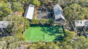 Gainesville townhouse for rent - a tennis court in the middle of a backyard surrounded by trees