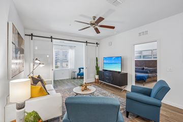 Tampa apartment for rent - A living room with a blue chair and a white couch.