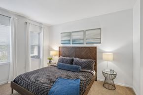 Tampa apartment for rent - A bedroom with a large bed and a small table.