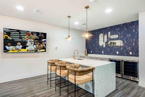 Gainesville apartment for rent - A kitchen with a bar area and a large painting of a basketball game on the wall.