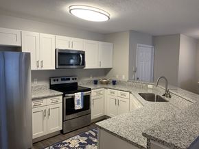 Gainesville apartment for rent - Compass kitchen with white cabinets and stainless steel appliances